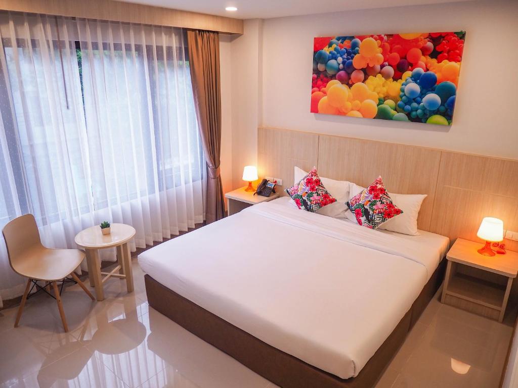 ein Schlafzimmer mit einem großen Bett und einem Gemälde an der Wand in der Unterkunft Malee Hotel in Chiang Mai