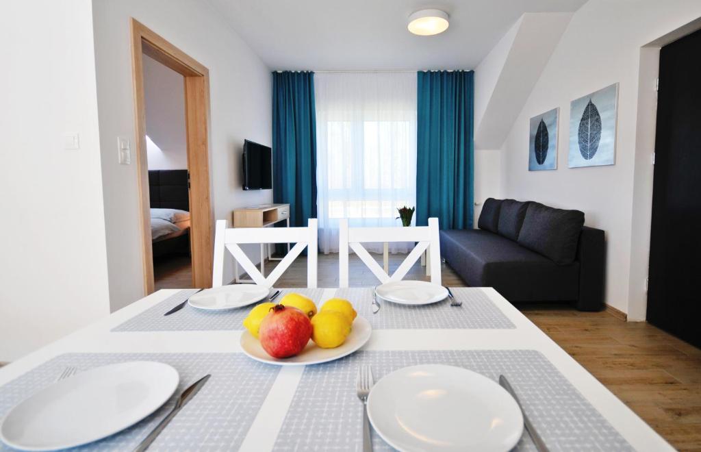 グジボボにあるVilla Blanca - Apartamentyのリビングルーム(テーブル、皿、フルーツ付)