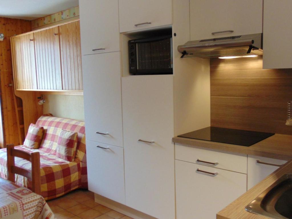 een kleine keuken met witte kasten en een wastafel bij Studio Chamonix-Mont-Blanc, 1 pièce, 2 personnes - FR-1-517-23 in Chamonix-Mont-Blanc