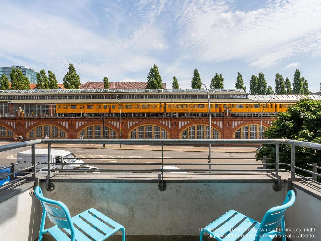 two blue chairs sitting in front of a train at numa I Kater Apartments in Berlin