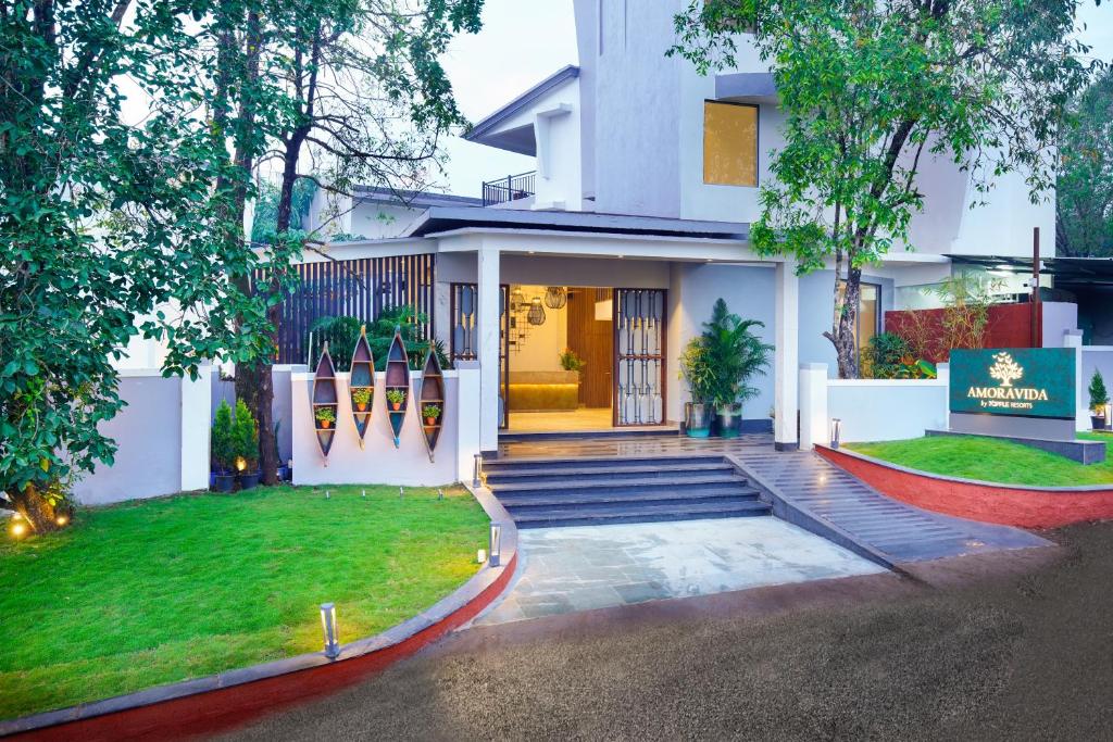 a white house with a staircase leading to the front door at Amoravida By 7 Apple Resorts, Goa in Mandrem