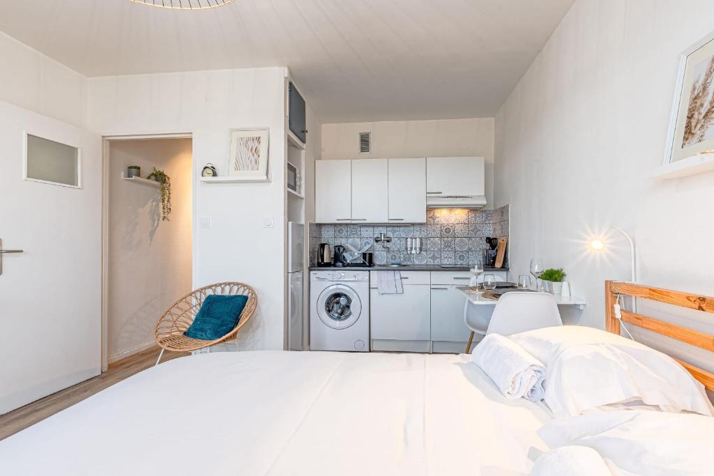 a bedroom with a large white bed and a kitchen at L&#39;Horizon in Metz