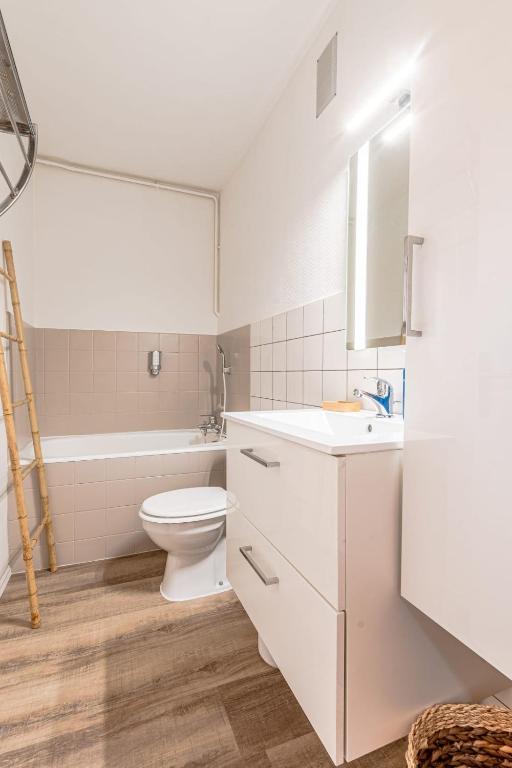 a white bathroom with a toilet and a sink at L&#39;Horizon in Metz