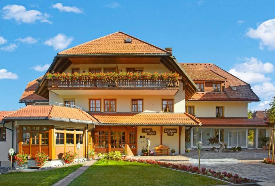 a large house with a balcony on top of it at Wander- & Wellnesshotel Nägele in Höchenschwand