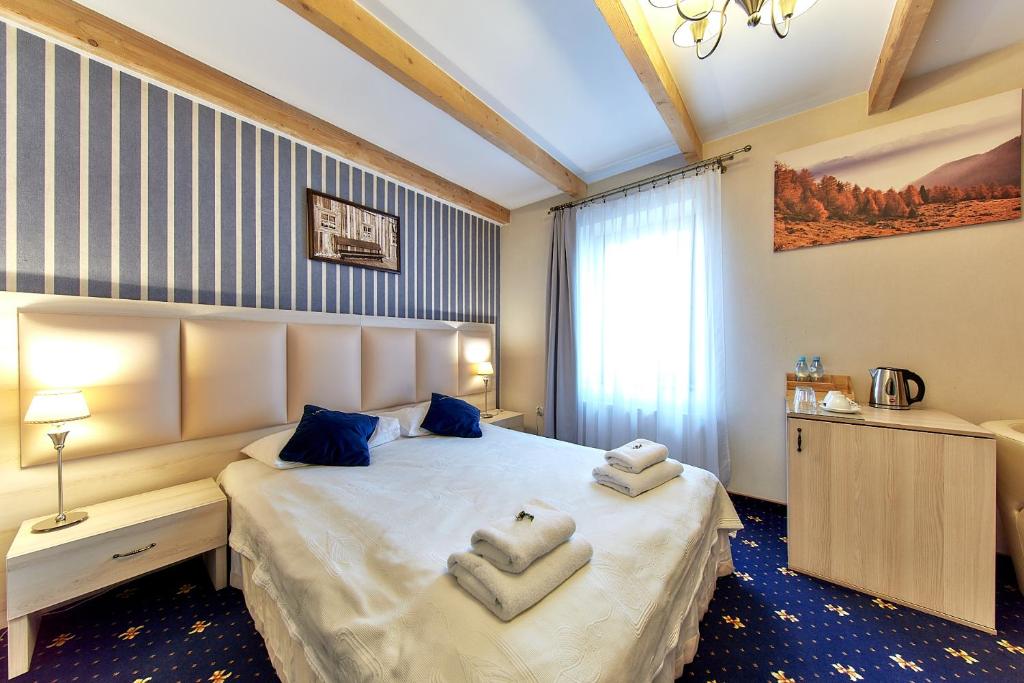 1 dormitorio con 1 cama con toallas en Willa Labelle, en Zakopane