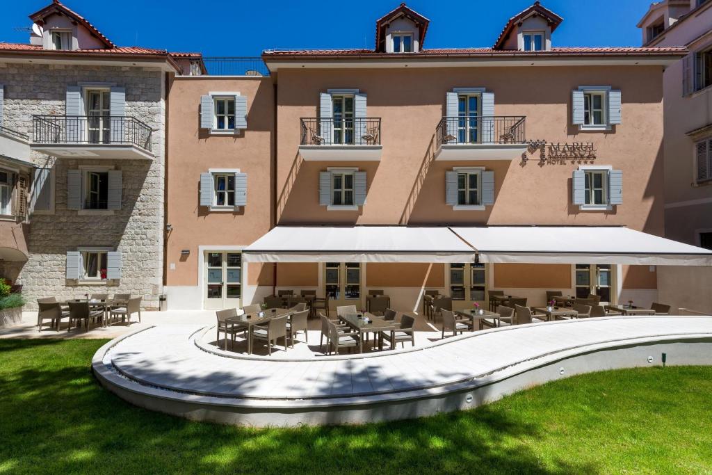 a building with tables and chairs in front of it at Hotel Marul in Split