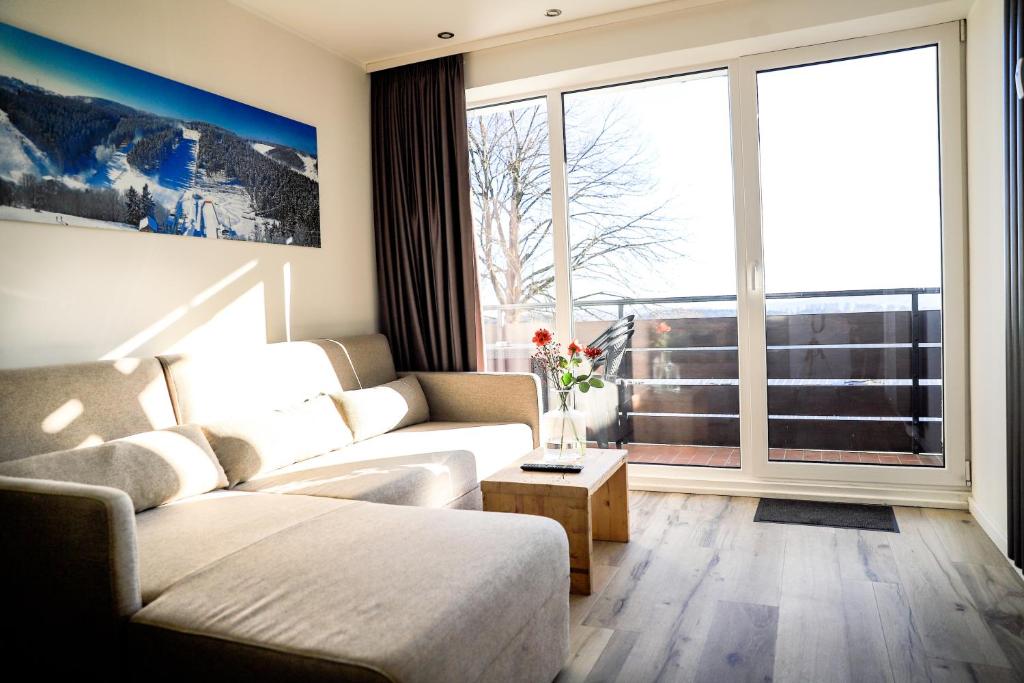 uma sala de estar com um sofá e uma grande janela em Smart Resorts Haus Saphir Ferienwohnung 508 em Winterberg