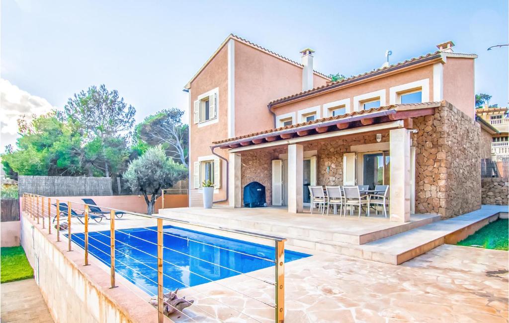 una villa con piscina di fronte a una casa di Lovely Home In Mallorca With Wifi a Cala Mesquida