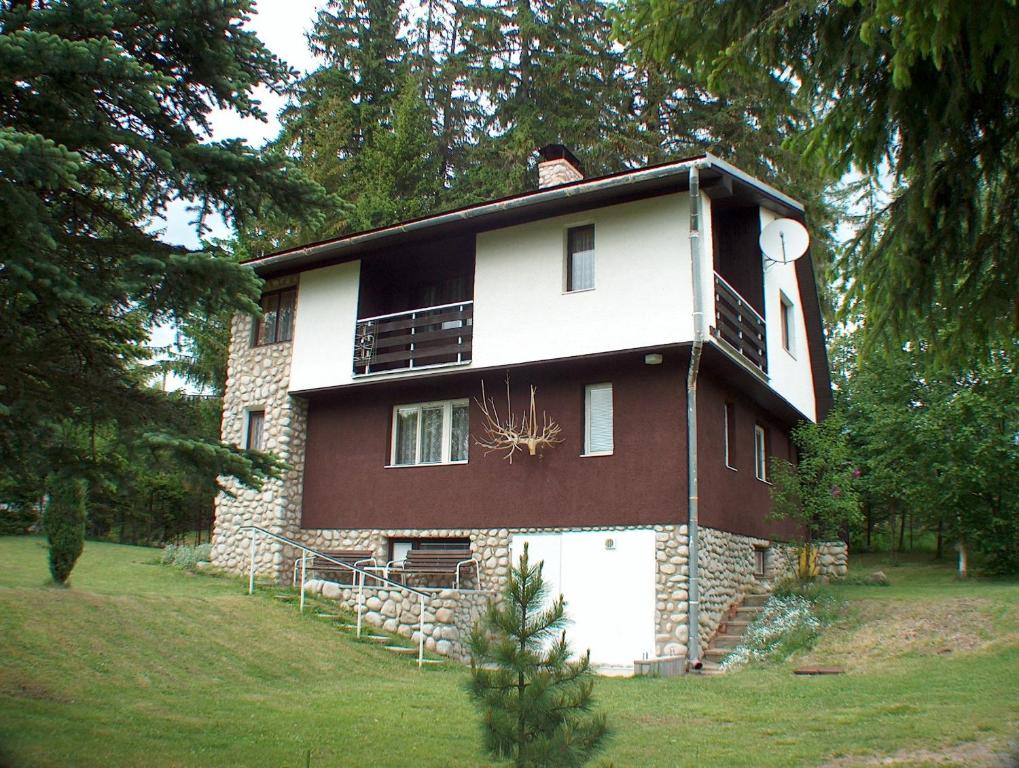 ein großes Backsteinhaus in einem Hof mit Bäumen in der Unterkunft Dušan in Štôla