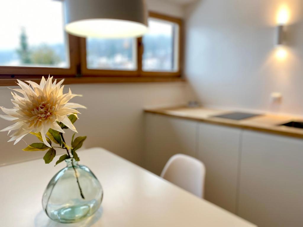 un jarrón con una flor en él sentado en una mesa en Gemütliche Ferienwohnung am Tegernsee - ruhig im Dachgeschoss, en Bad Wiessee