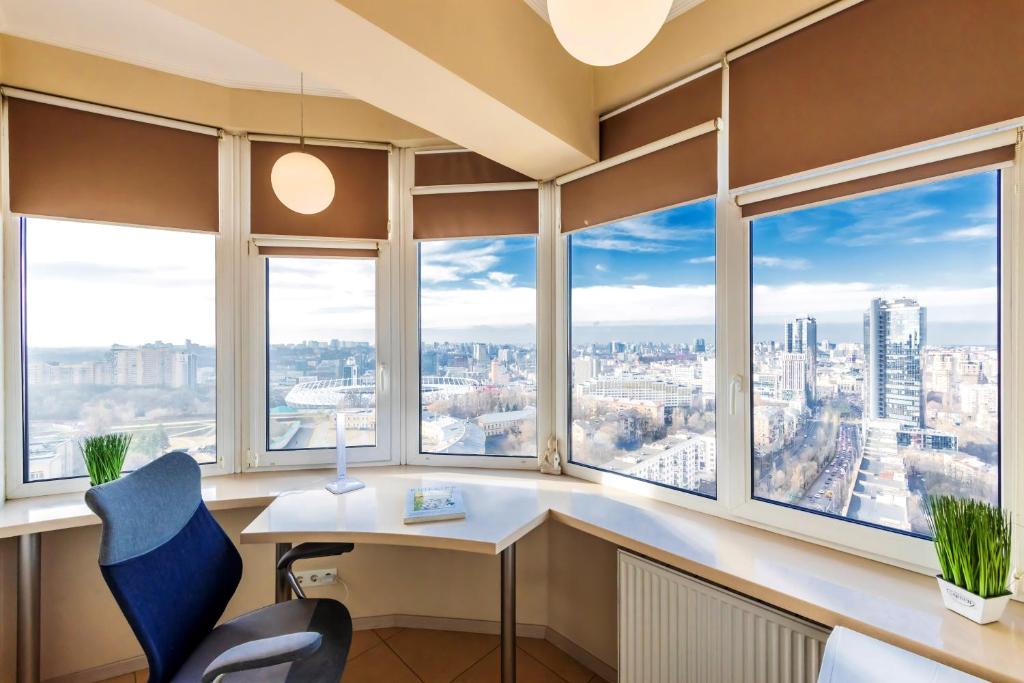 an office with a desk and a view of the city at Центр, 20 поверх! 2к квартира із панорамою in Kyiv
