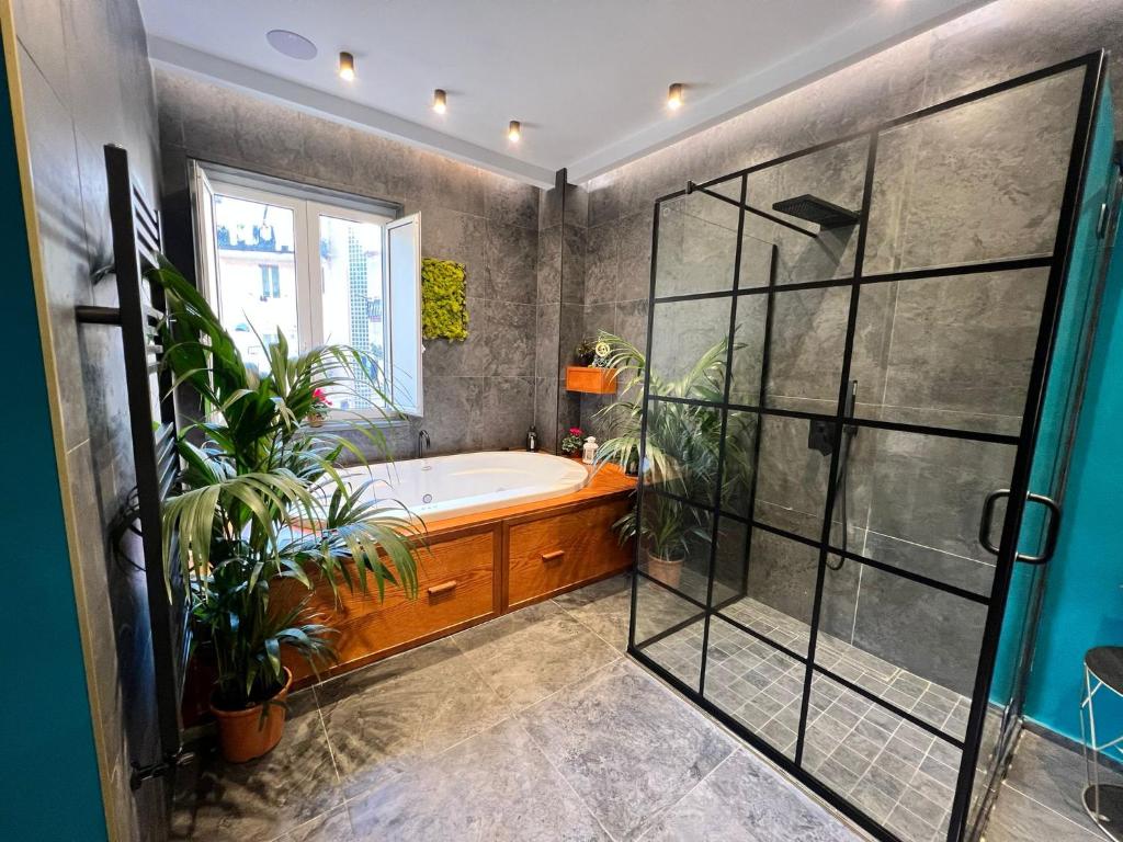ein Badezimmer mit einer Badewanne und Topfpflanzen in der Unterkunft ORLANDO relais in Neapel