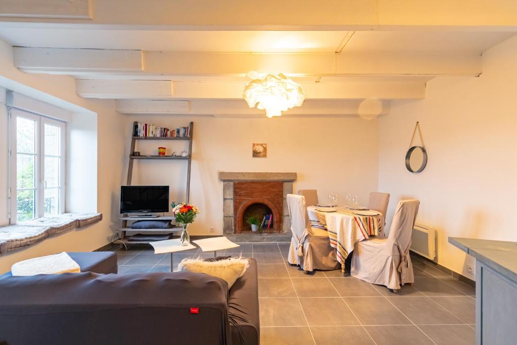 a living room with a table and a fireplace at La Grand Voile - maison 4 chambres vue mer - plage à 900 m in Saint-Pol-de-Léon