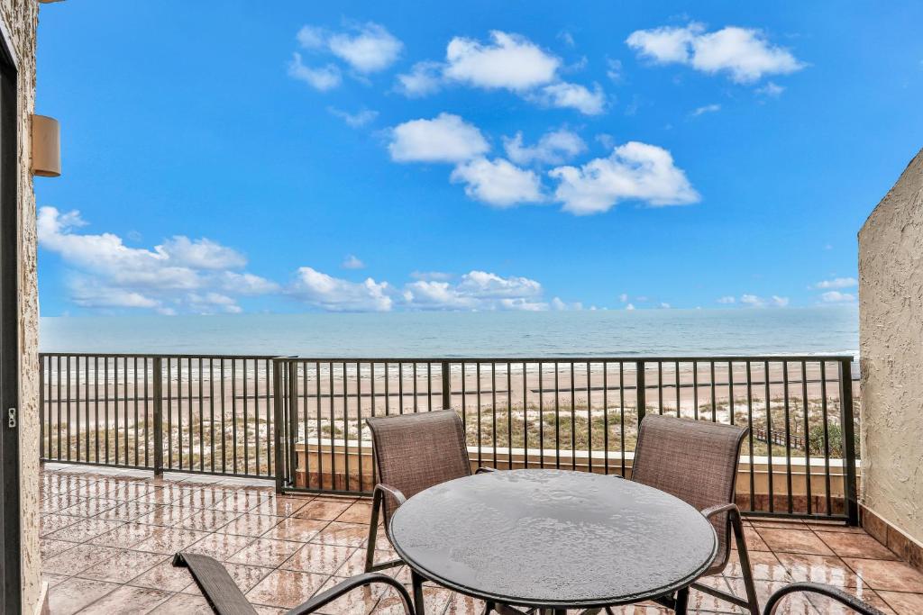 a patio with a table and chairs and the ocean at Sea Dunes Penthouse in Fernandina Beach