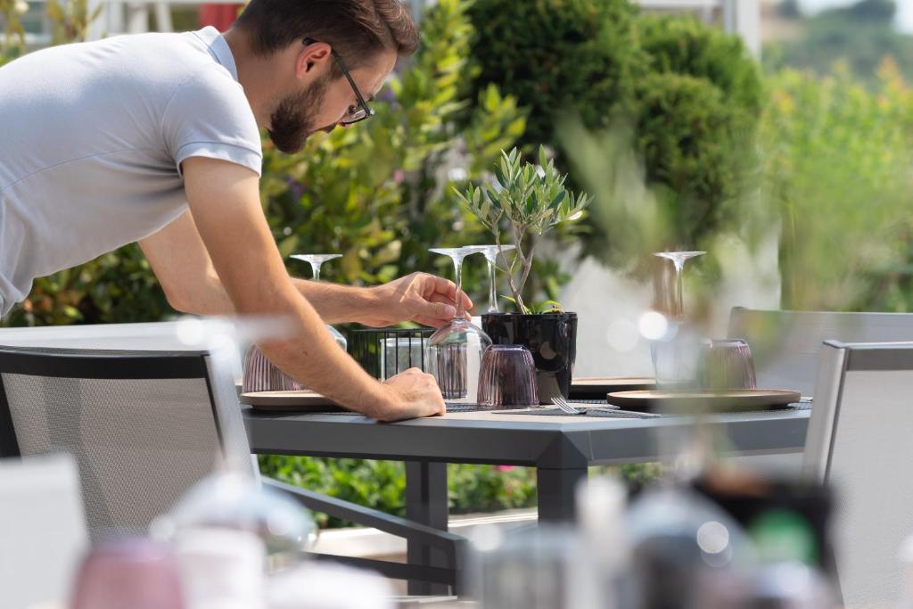 a man is sitting at a table with a table at Akti Toroni Boutique Hotel in Toroni