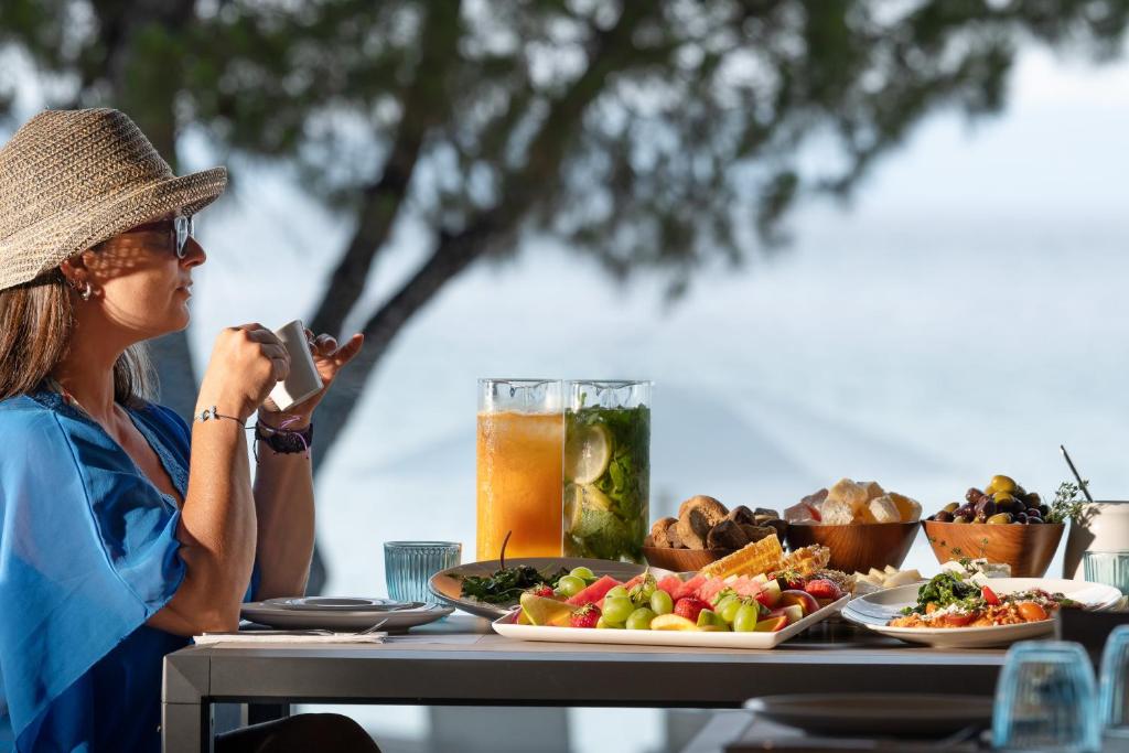 a woman taking a picture of a table of food at Akti Toroni Boutique Hotel in Toroni