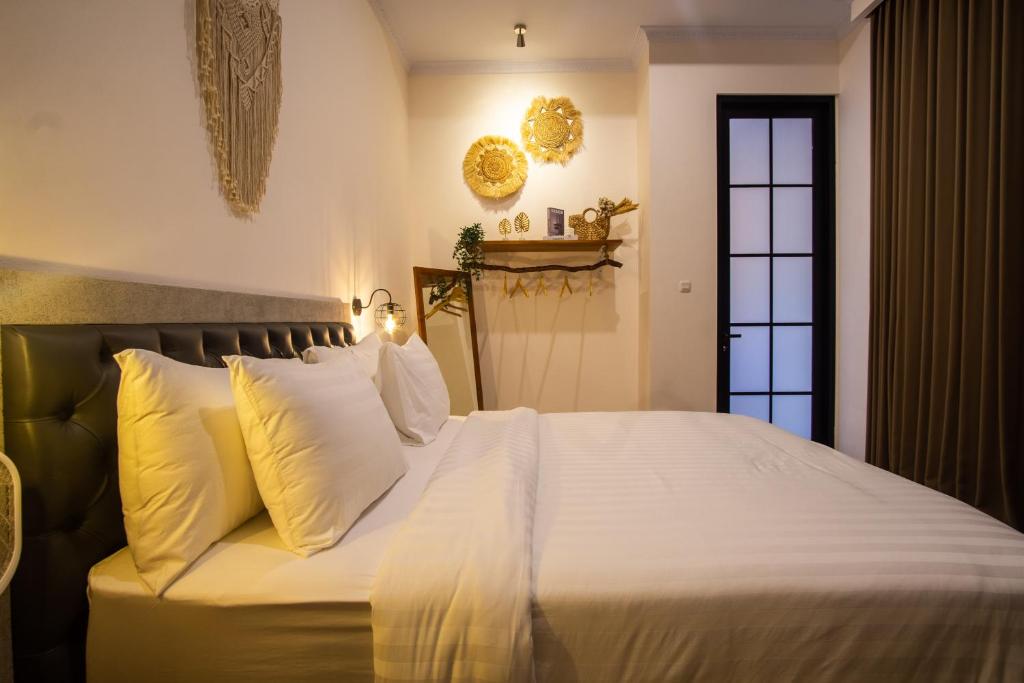 a bedroom with a large bed with white sheets and pillows at Kamaratih Villas by Maheswara in Legian
