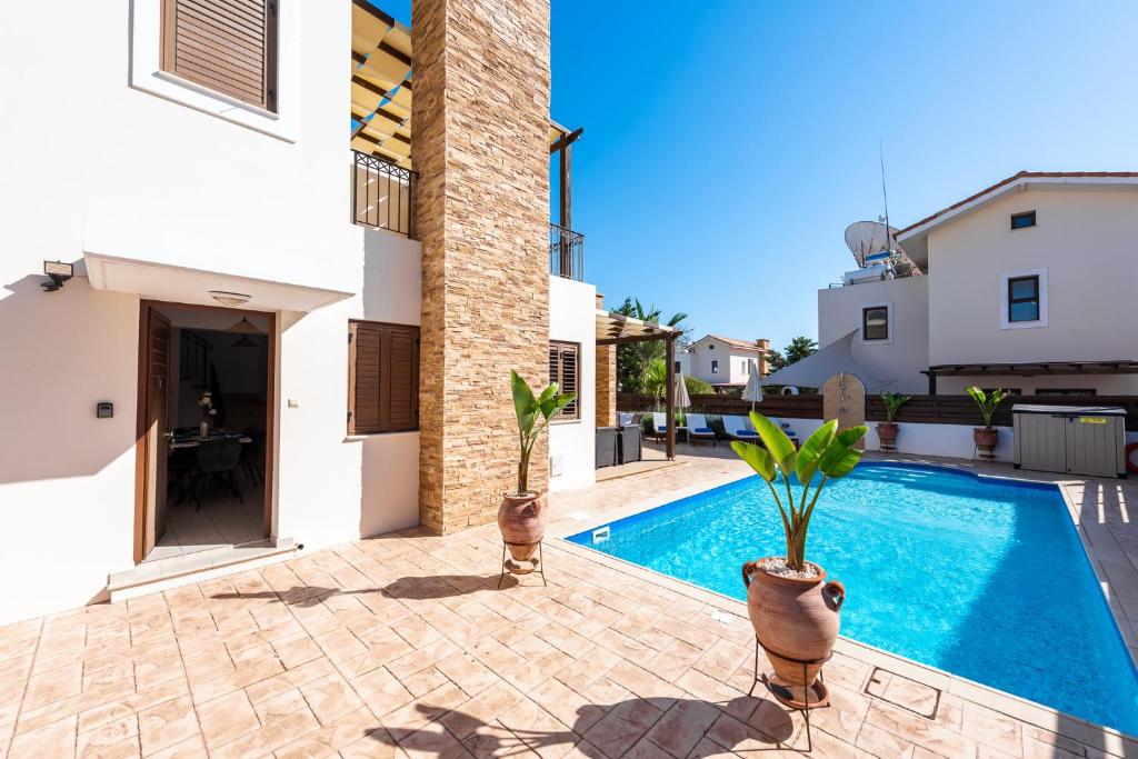 een villa met een zwembad en een huis bij Villa Iris by Ezoria Villas in Ayia Napa