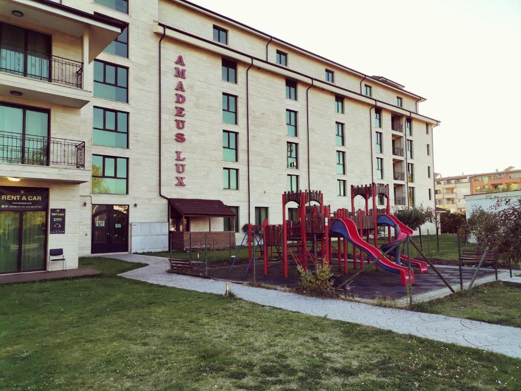 um hotel com um parque infantil em frente a um edifício em Family Apartments Amadeus lux em Sunny Beach
