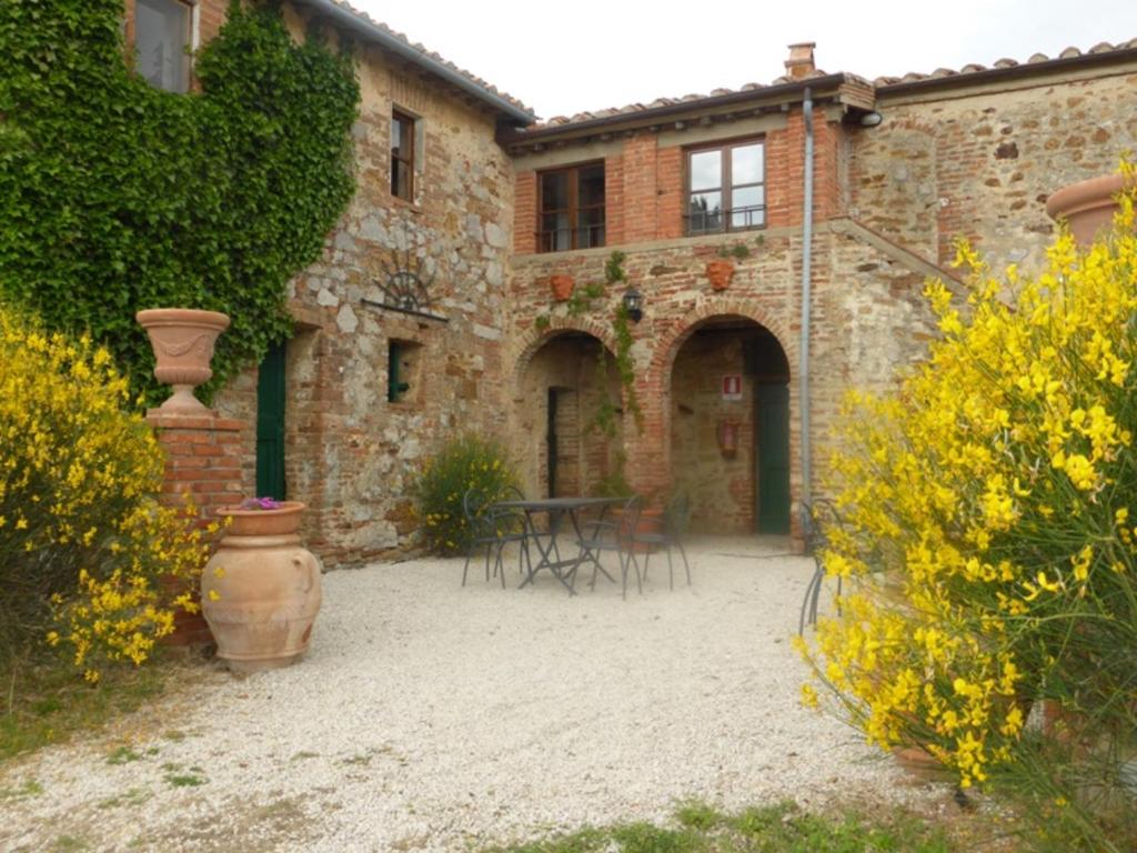 a courtyard of a building with a table and chairs at Villa Cenerentola in Trequanda