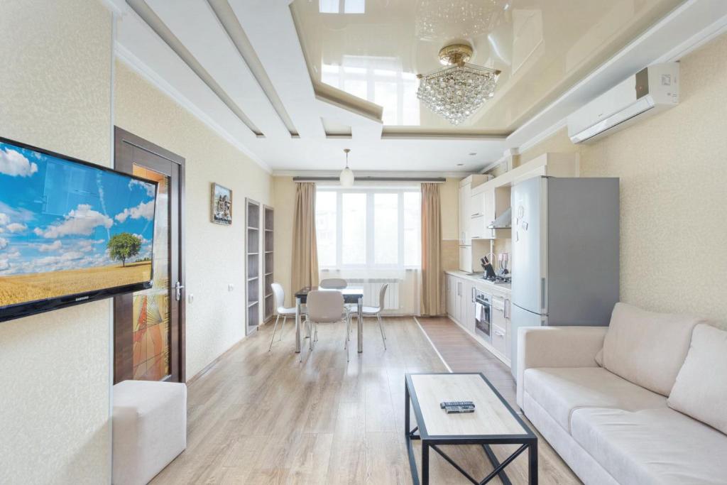 sala de estar con sofá blanco y mesa en Stay Inn Apartments on 33 Sayat-Nova avenue, en Ereván