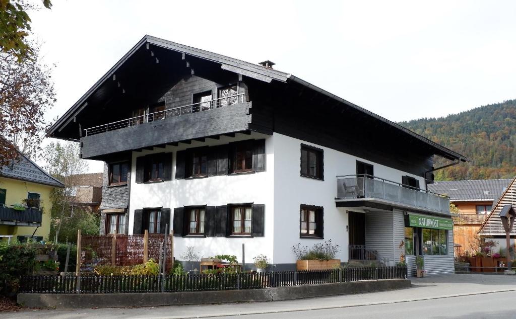 una casa bianca con tetto nero di D`Alpenapartments Bezau a Bezau