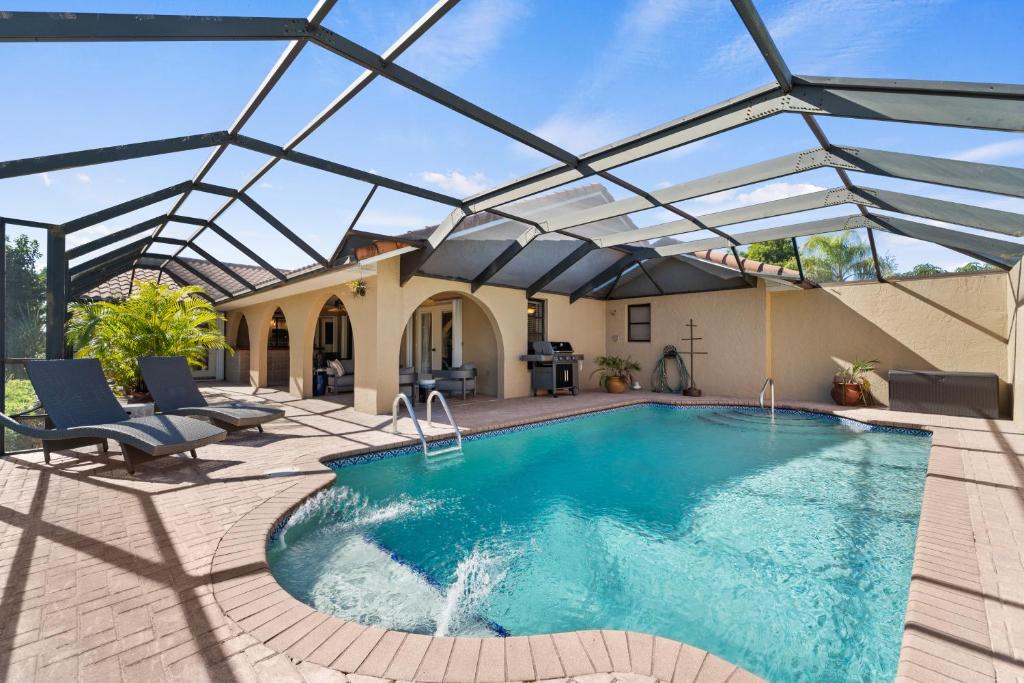 a swimming pool with a glass roof on a patio at Waterfront Retreat in Punta Gorda