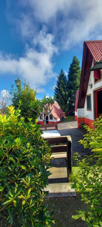 um banco de madeira sentado em frente a um edifício em Santana Houses - Mountain Shelter bungallows em Santana