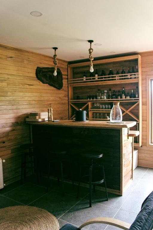 a bar in a room with wooden walls and stools at Cabañas Arrayanes de Huillinco en Chiloé in Chonchi