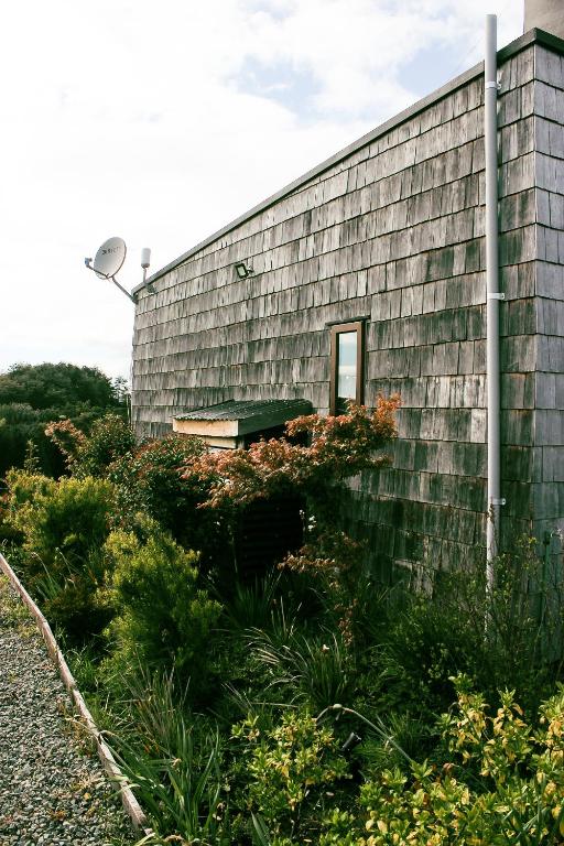 a building with a bench on the side of it at Cabañas Arrayanes de Huillinco en Chiloé in Chonchi