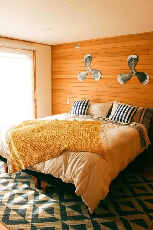 a bedroom with a large bed with two fans at Cabañas Arrayanes de Huillinco en Chiloé in Chonchi