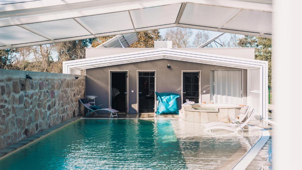 uma piscina em frente a uma casa em Arca dos Animais - Farming & SPA em Castelo Branco