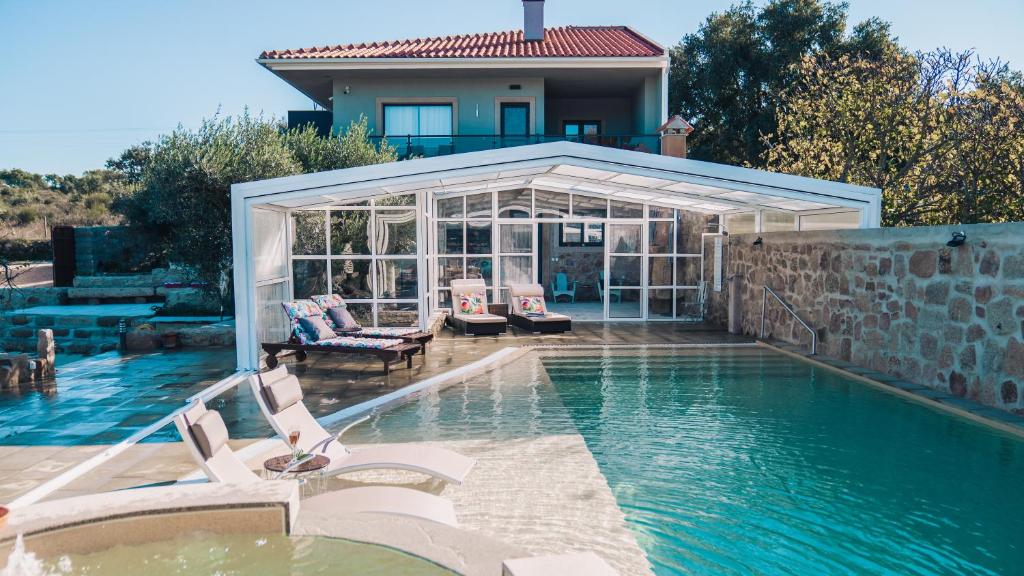 a house with a swimming pool and a house at Arca dos Animais - Farming & SPA in Castelo Branco