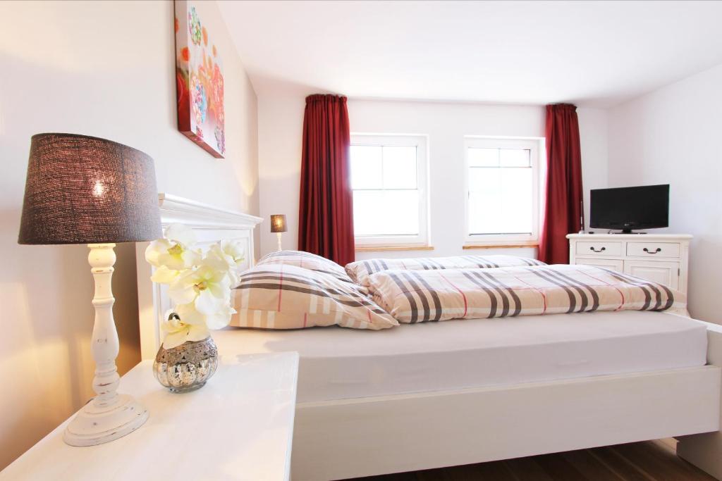 a bedroom with a bed with red curtains at Gästehaus Münks in Meerbusch