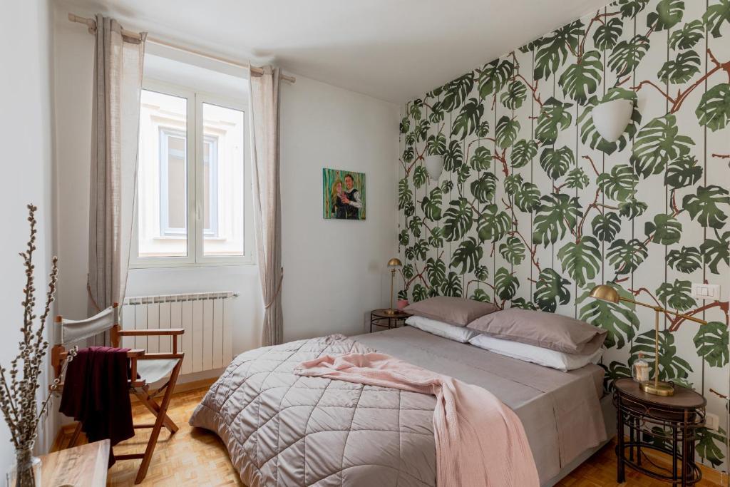 1 dormitorio con 1 cama con papel pintado frondoso en Giglio quiet apartment at Campo dei Fiori, en Roma