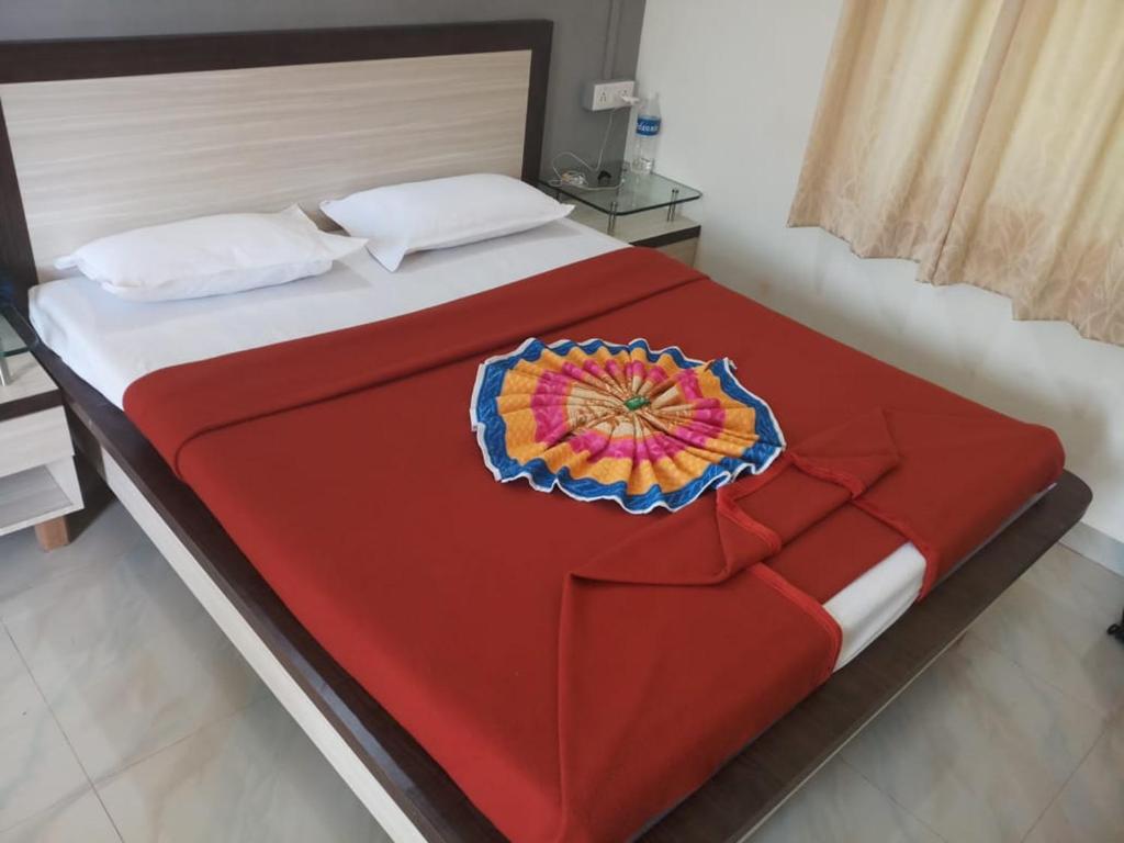 een groot bed met een rode deken erop bij Sai Sagar Beach Niwas in Malvan