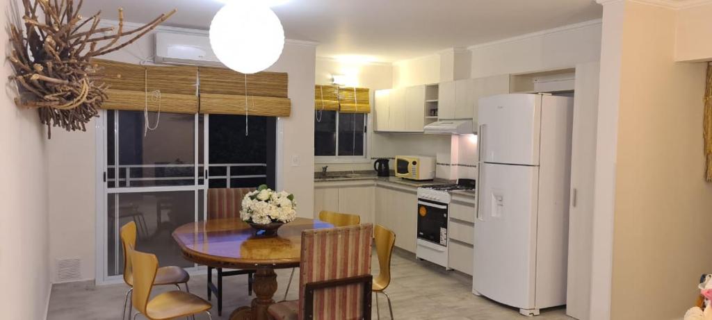 a kitchen with a table and chairs and a refrigerator at Carlos Paz - 3 Dormitorios con cochera - Zona céntrica residencial in Villa Carlos Paz