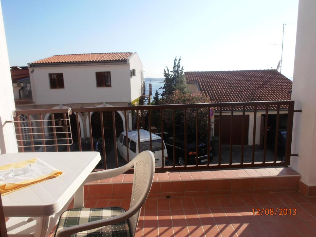 a balcony with a table and a white table and chairs at Apartments Meni in Drage