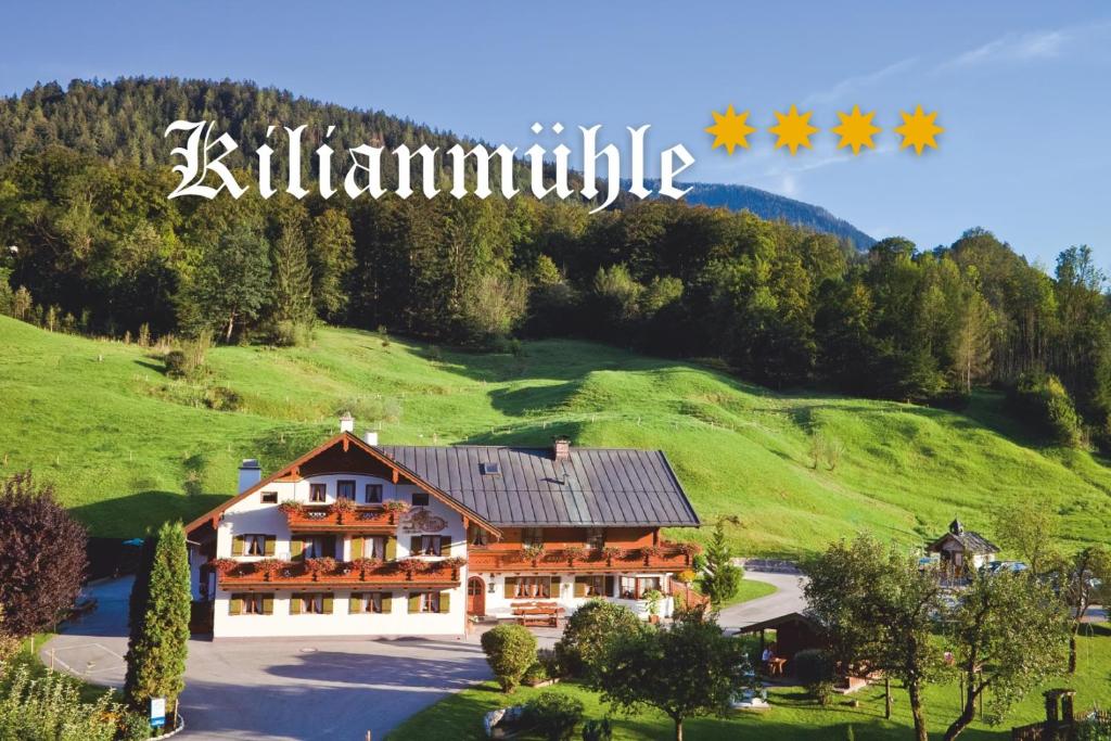 una casa en una colina con un cartel que lee Killmannulic en Ferienwohnung Kiliansblick in der Kilianmühle, en Berchtesgaden