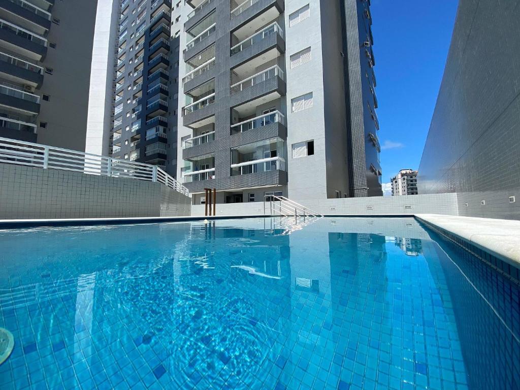 a swimming pool in front of two tall buildings at Flat Unitá Homestay in Praia Grande