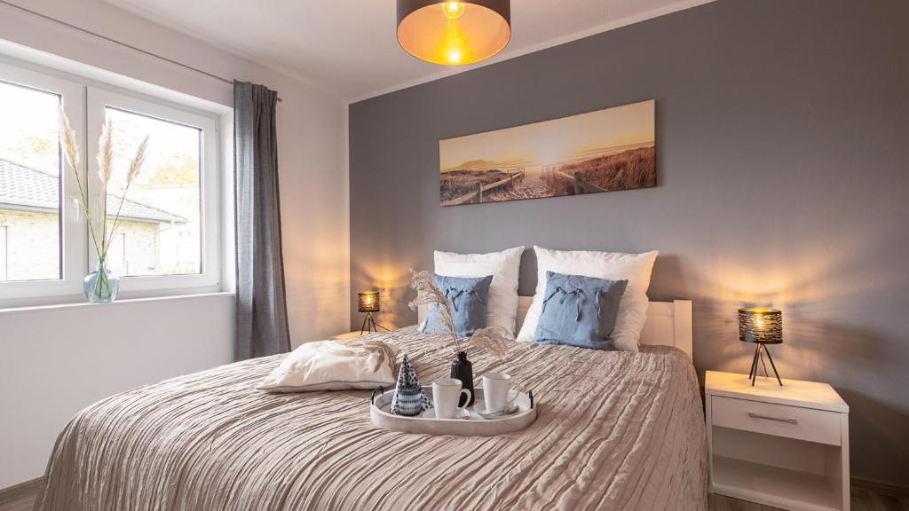 ein Schlafzimmer mit einem Bett und einem Tablett darauf in der Unterkunft Ferienhaus Sonneneck am Harkebrügger See mit Sauna in Barßel