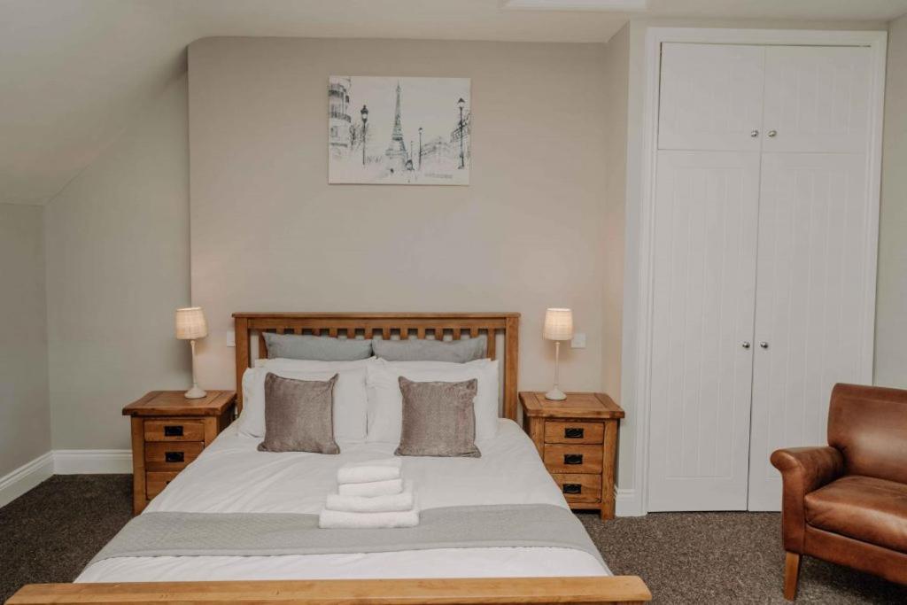 a bedroom with a large bed and a chair at Russet in Lucker
