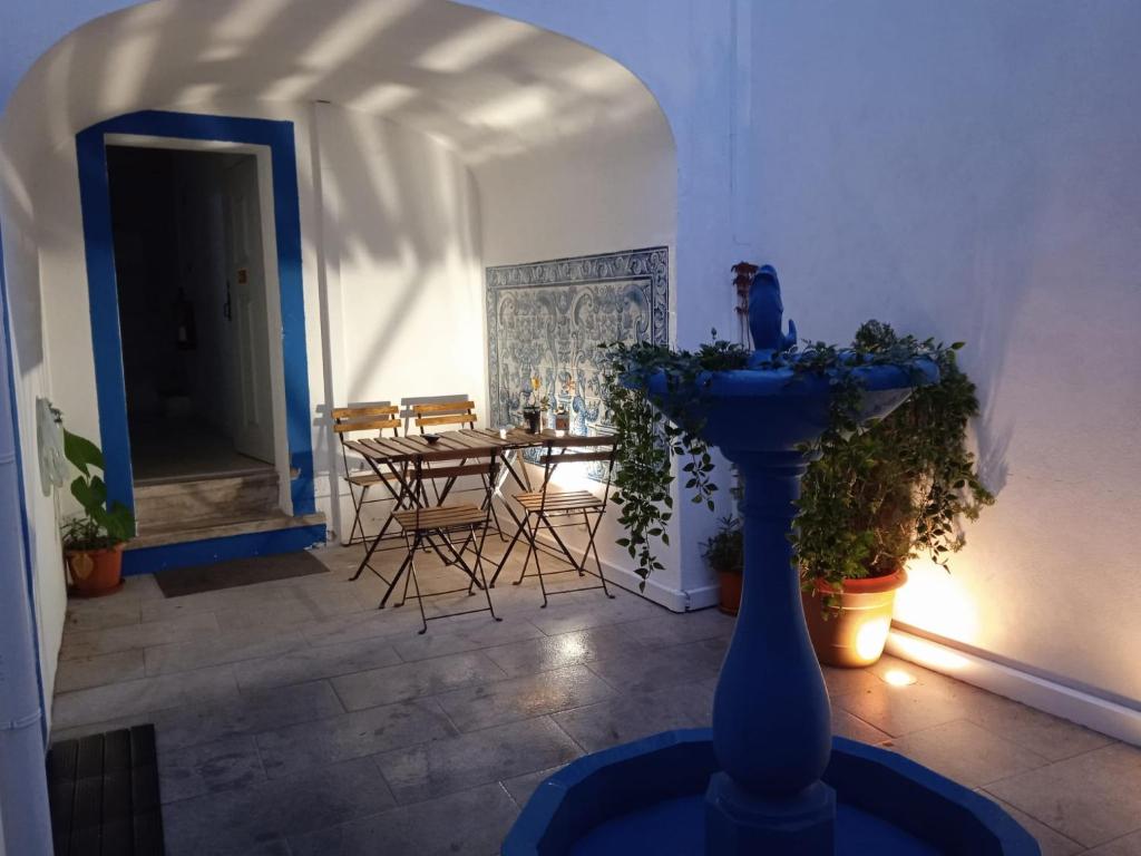 uma sala de estar com uma mesa e um vaso azul em Old Évora Hostel em Évora