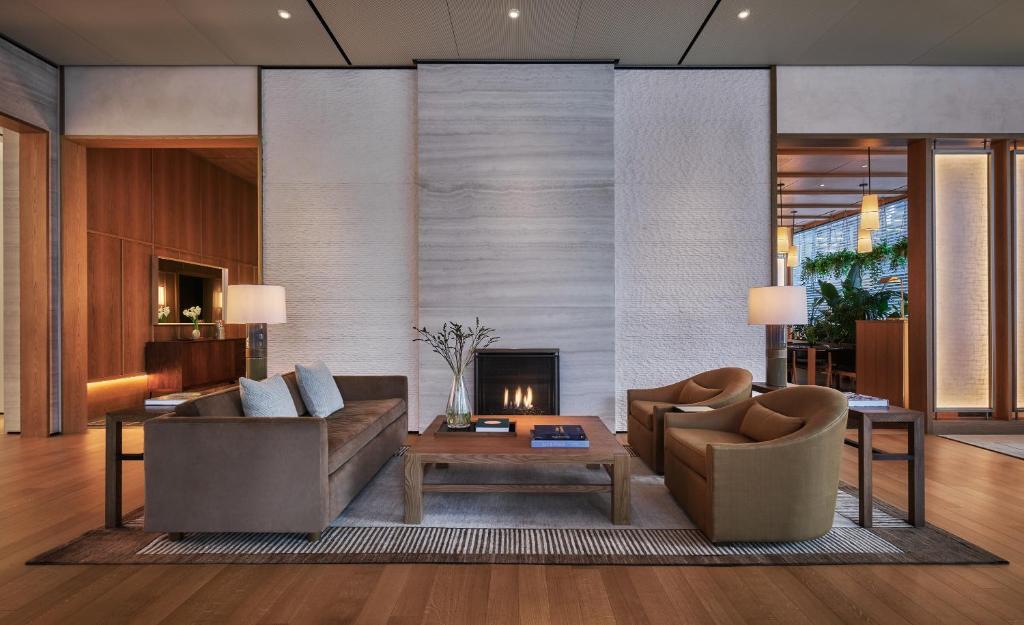 a living room with two couches and a fireplace at Pendry Manhattan West in New York