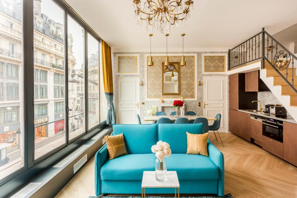 a living room with a blue couch and large windows at Luxury 3 bedroom 2 bathroom Apartment - LOUVRE - with AC in Paris