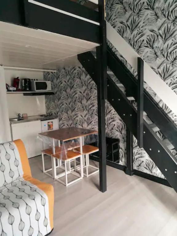 Cette chambre comprend une table et des lits superposés. dans l'établissement Le repos chavagnais, à Chavagnes-en-Paillers