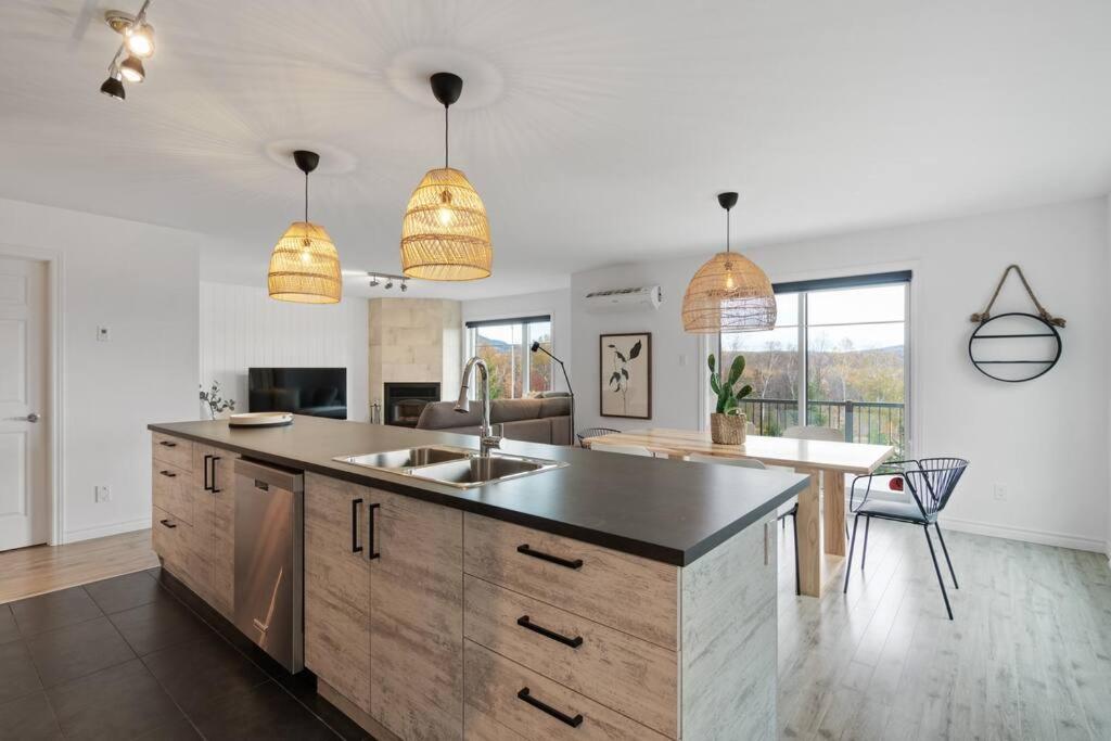 a kitchen with a sink and a counter top at INITIAL - BOHO - Mont-Sainte-Anne in Beaupré