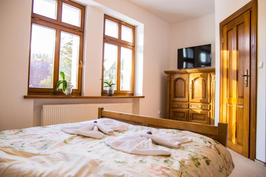 una camera da letto con un letto e asciugamani di Dzika Róża a Szklarska Poręba
