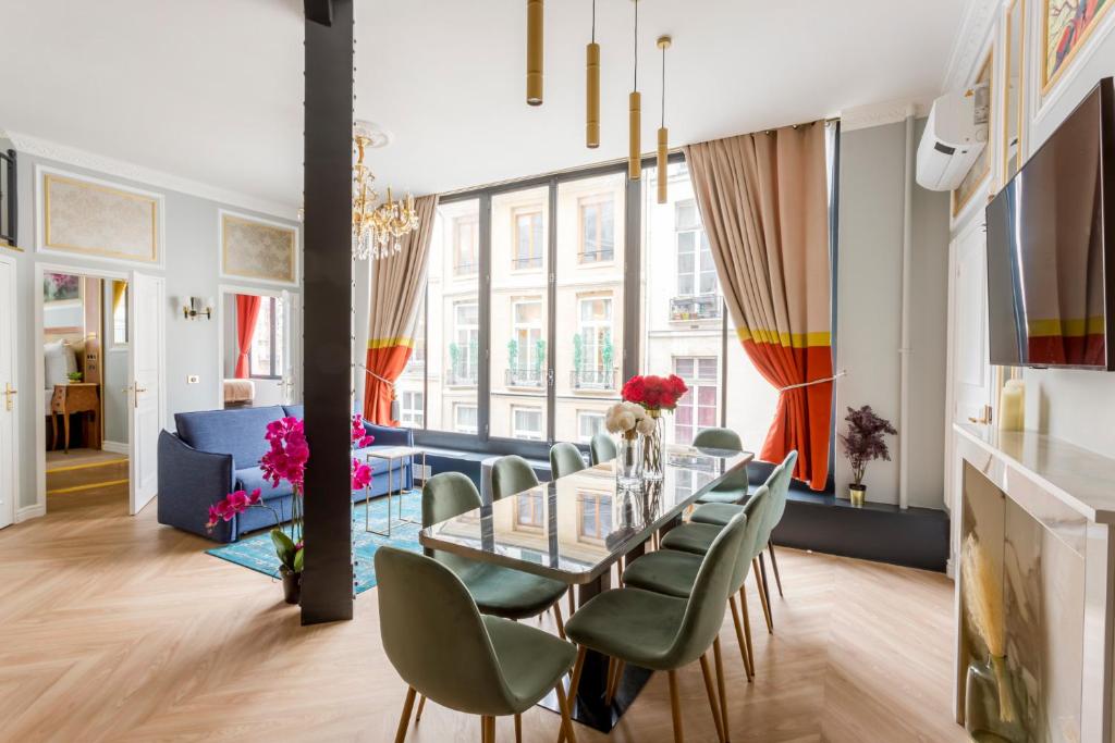 a dining room with a glass table and green chairs at Luxury 4 bedroom 2 bathroom Apartment in Paris