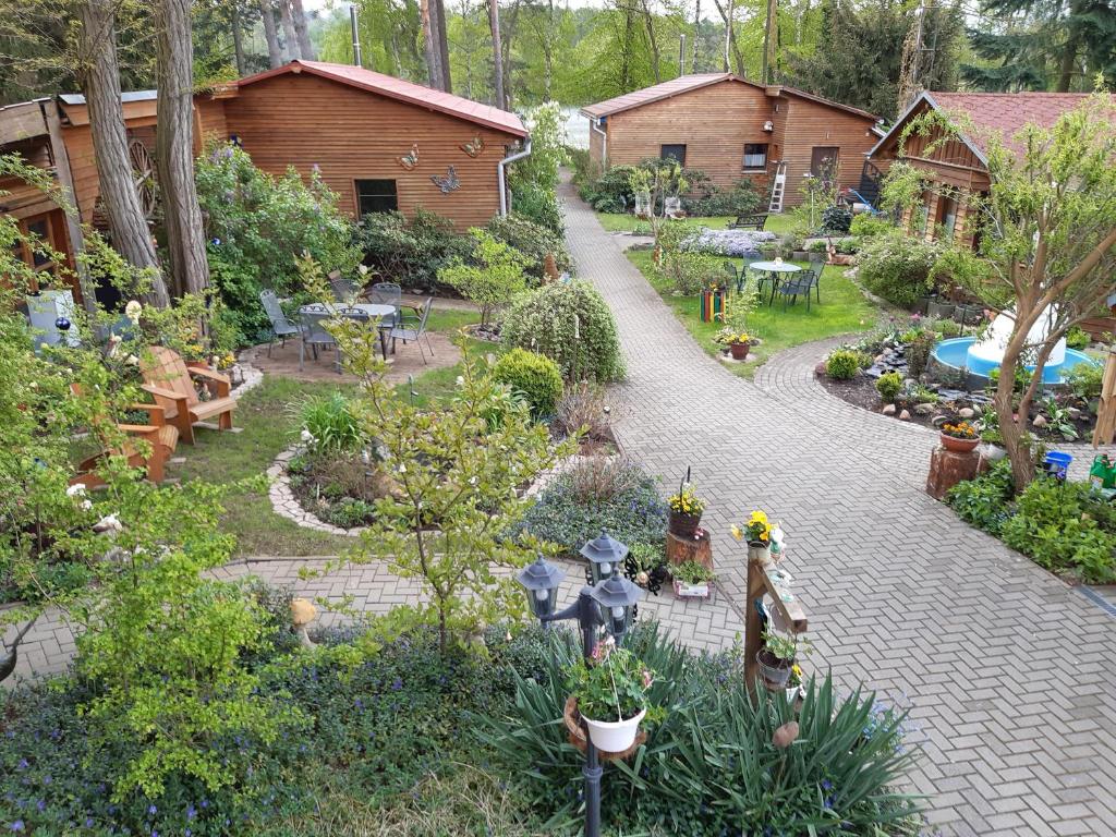 um jardim com uma passarela de tijolos num quintal em Monikas Gästehäuser Seeblick Himmelpfort em Pian